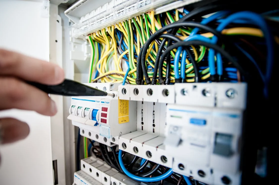Repairman fixes switchboard for energy efficient programs for Ontario businesses.